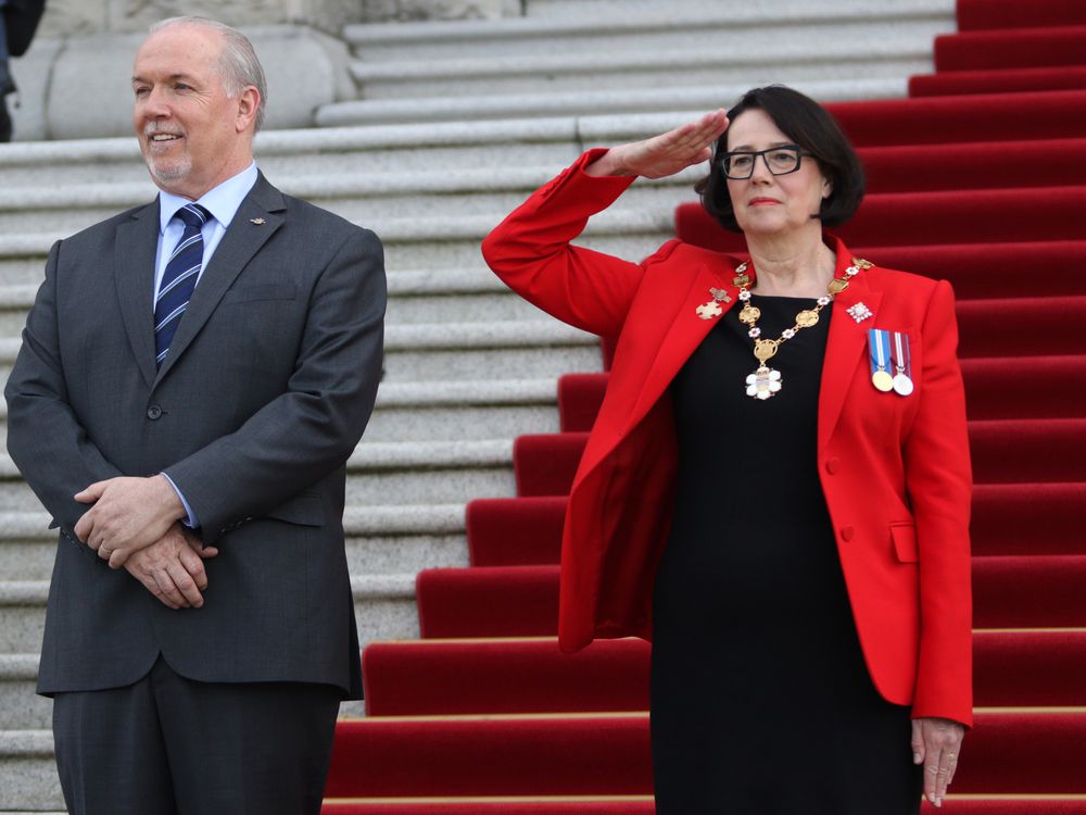 Premier John Horgan looks on as Lieutenant-governor Janet Austin salutes the 100-person Guard of Honour following the installation ceremony at Legislature in Victoria on Tuesday April 24, 2018. THE CANADIAN PRESS/Chad Hipolito