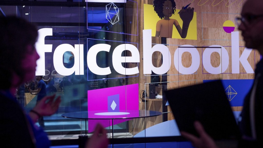 Conference workers speak in front of a demo booth at Facebook's annual F8 developer conference, in San Jose, Calif. in this April 18, 2017 file photo A Facebook executive with ties to the ruling Liberals was grilled today about his preferential access to senior members of the Trudeau cabinet, even though no one from the social-media giant, including himself, is a registered lobbyist in Canada. THE CANADIAN PRESS/AP/Noah Berger